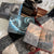 Three books with dragon and fantasy-themed illustrated endpapers on a checkered fabric surface with a typewriter and bottle. image