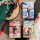 Three hardcover books by Tia Williams arranged on a textured blanket with a green book box, pinecones, and a small bottle. The book covers feature illustrated romance scenes: 'The Perfect Find', 'Seven Days in June', and 'A Love Song for Ricki Wilde'.