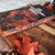 A hardcover book titled "The Prisoners of the Mountain" by Mark Lawrence, styled on a rustic wooden board with autumn leaves and pinecones. image
